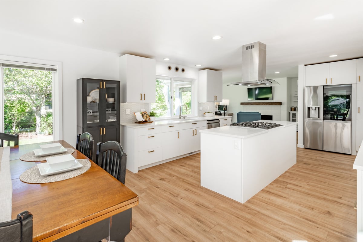 Spacious white kitchen with gold fixtures and open concept